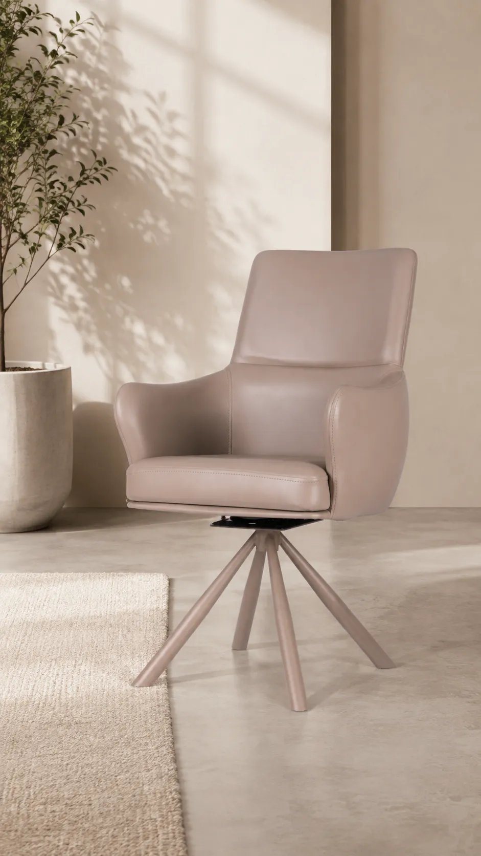 A taupe swivel dining chair on a pale floor in front of an arched wall